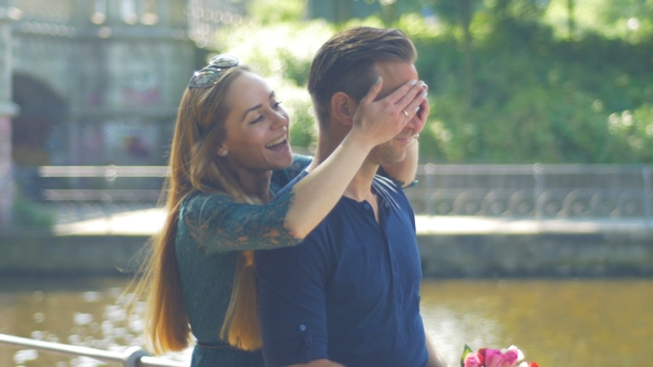 A Man Waiting for His Girlfriend with a Bunch of Flowers and Is Surprised By Her