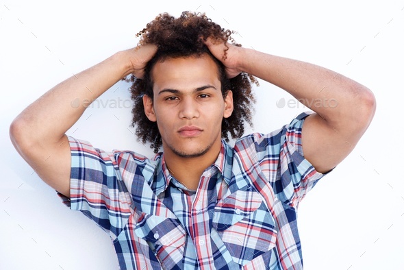 cool young guy staring with hands in hair