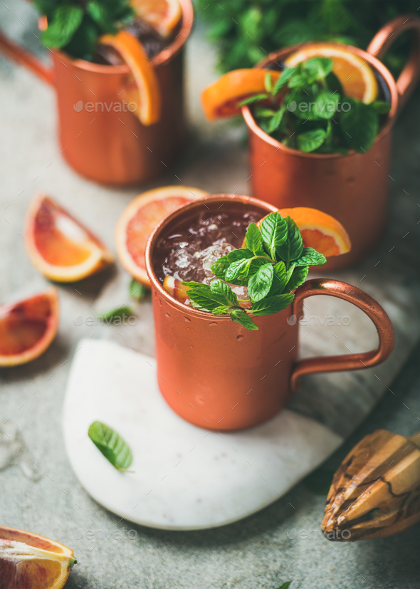 Blood orange Moscow mule alcohol cocktails in mugs on board - Stock Photo - Images
