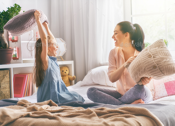 mother and her child are fighting pillows Stock Photo by choreograph