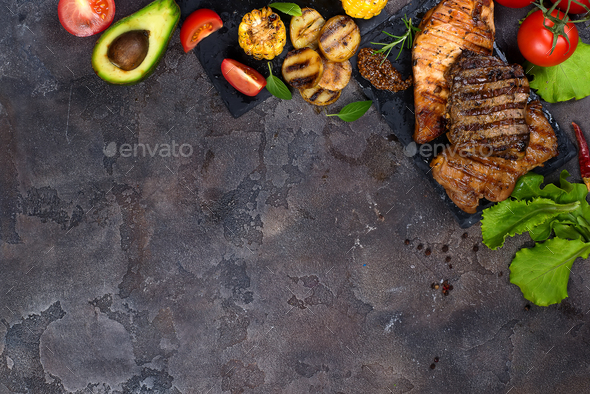 Fresh three types of grilled steak on slate plate with herbs, tomato, avocado and grilled potatoes - Stock Photo - Images