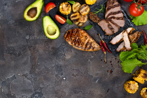 Fresh three types of grilled steak on slate plate with herbs, tomato, avocado and grilled potatoes - Stock Photo - Images