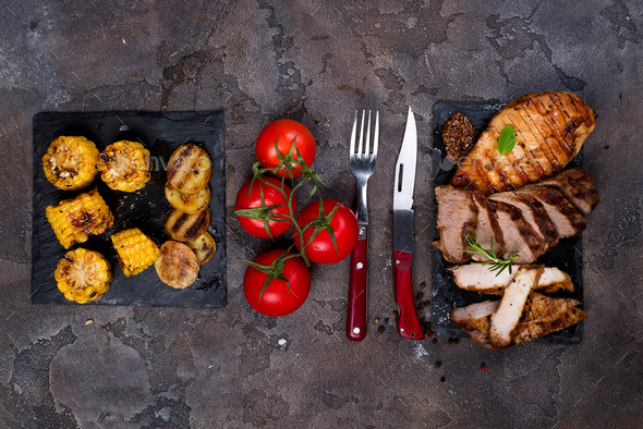 three types of grilled steak on slate plate with herbs, corn, tomato - Stock Photo - Images
