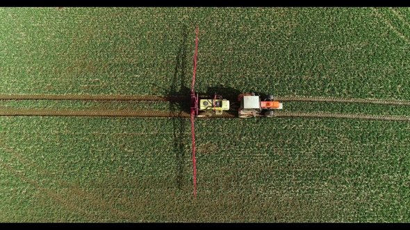 Tractor Spray Fertilize on Field with Chemicals in Agriculture Field alt