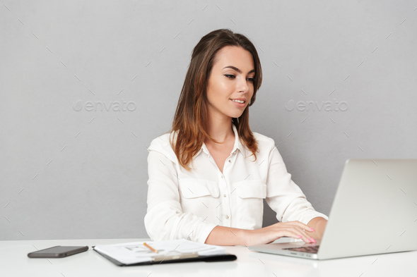 Portrait of a happy young business woman working - Stock Photo - Images