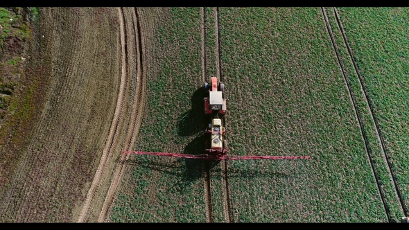 Tractor Spray Fertilize on Field with Chemicals in Agriculture Field alt
