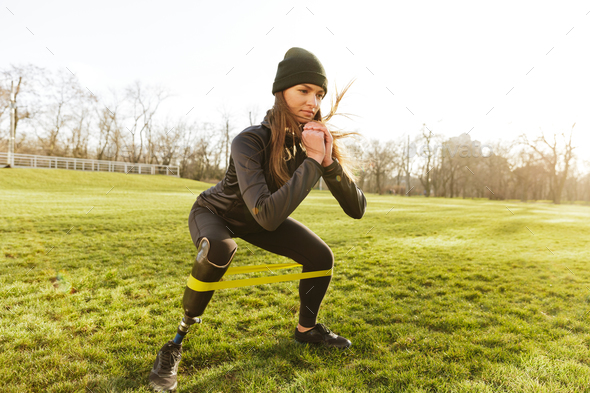 Photo of concentrated disabled girl in tracksuit, doing sports a - Stock Photo - Images