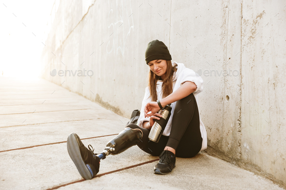 Photo of content handicapped woman having bionic leg in streetwe Stock Photo by vadymvdrobot