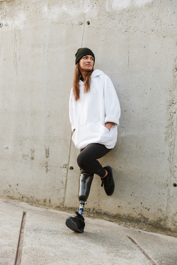 Photo of caucasian disabled girl with bionic leg in casual wear, Stock Photo by vadymvdrobot