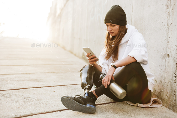 Photo of pretty young handicapped woman in streetwear having bio - Stock Photo - Images