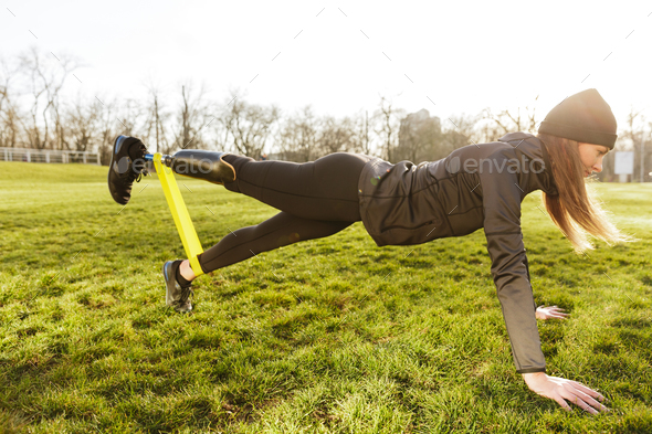 Image of sporty handicapped woman in black tracksuit, warming up - Stock Photo - Images