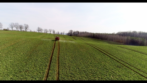 Tractor Spray Fertilize on Field with Chemicals in Agriculture Field alt