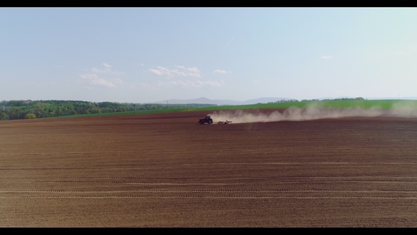 Tractor Working in Beautiful Spacious Agricultural Field alt