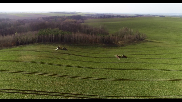 Tractor Spray Fertilize on Field with Chemicals in Agriculture Field alt