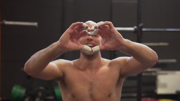 Fitness Man Shows Heart Gesture with Calloused Handsafter Hard Workout in Gym