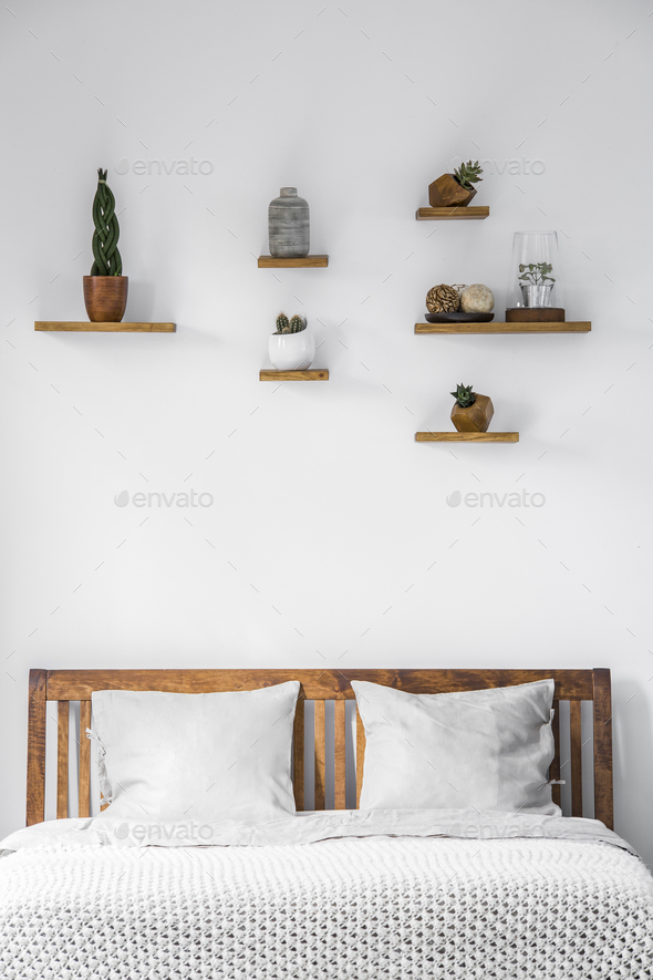 Close-up of a white wall with small decorations on shelves above - Stock Photo - Images