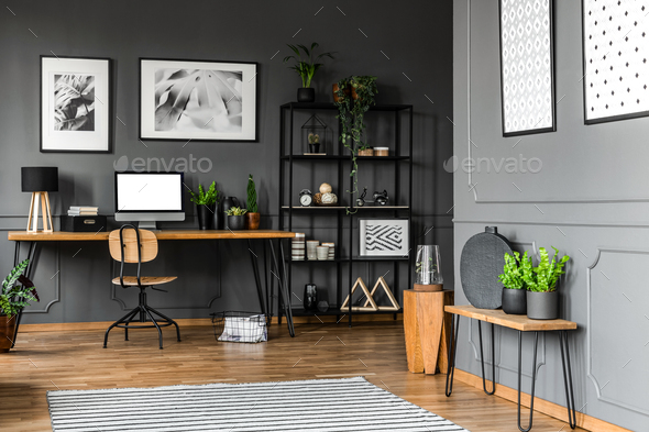 Black rack with decorations standing next to a wooden chair and - Stock Photo - Images