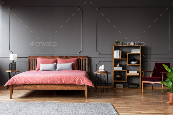 Real photo of a spacious bedroom interior with pink bed standing - Stock Photo - Images