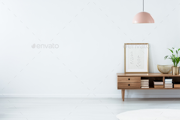 Pink lamp above wooden sideboard - Stock Photo - Images