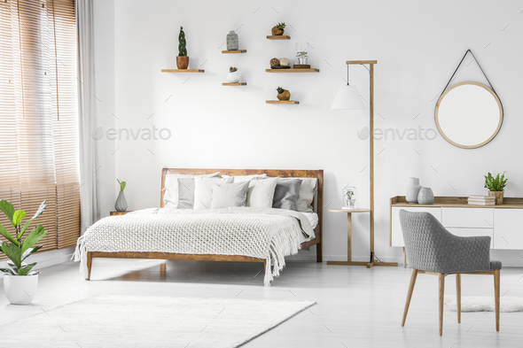 Front view of a bright natural bedroom interior with wooden bed - Stock Photo - Images