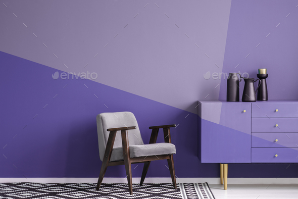 Real photo of a gray, wooden armchair on patterned, black and wh - Stock Photo - Images