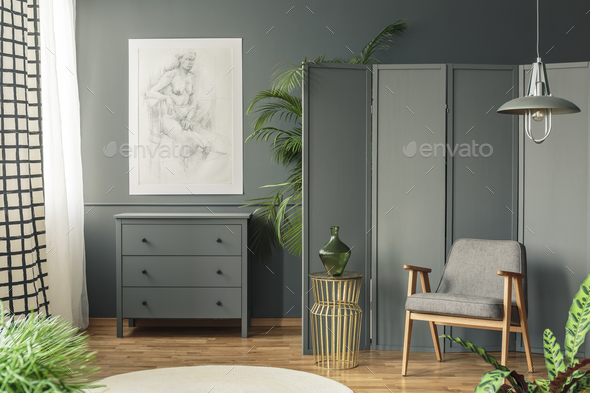Dark, gray living room interior with a sketch hanging above a wo - Stock Photo - Images