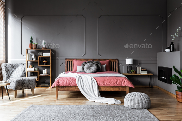 Real photo of a cozy bedroom interior with wooden bed in the mid - Stock Photo - Images