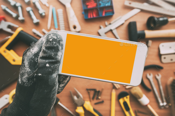 Repairman smart phone app, repairman holding mobile phone in han - Stock Photo - Images