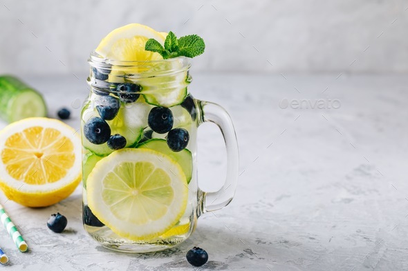 Infused detox water with lemon and cucumber slices, blueberry and mint. - Stock Photo - Images