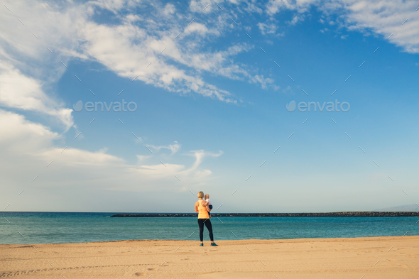 Mother with baby boy enjoy sunrise on a beach - Stock Photo - Images