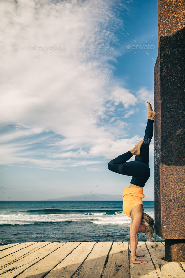 Yoga girl meditating and relaxing in yoga pose, ocean view Stock Photo by blas