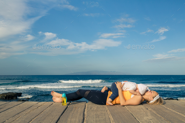 Baby boy playing with mother on the beach, summer day - Stock Photo - Images