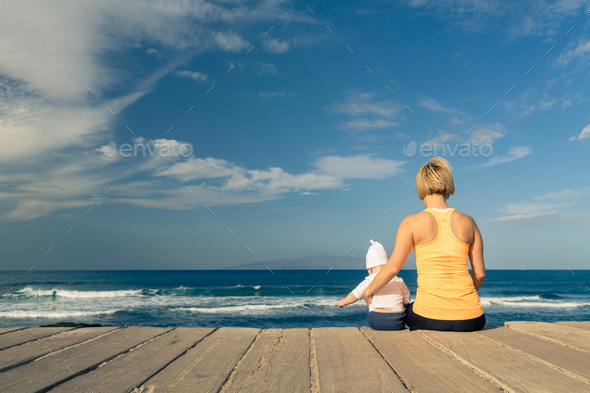 Baby boy playing with mother on the beach, summer day - Stock Photo - Images