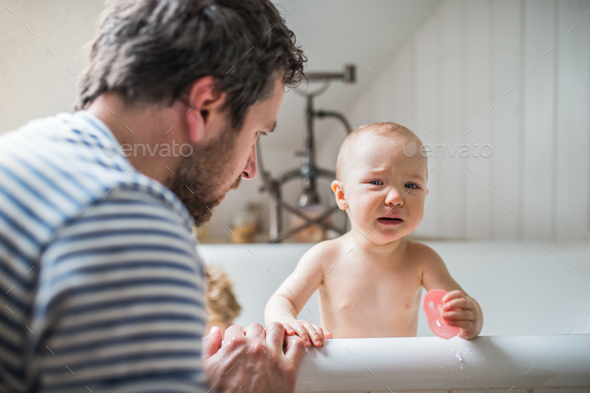 Father washing two toddlers in the bathroom at home. - Stock Photo - Images