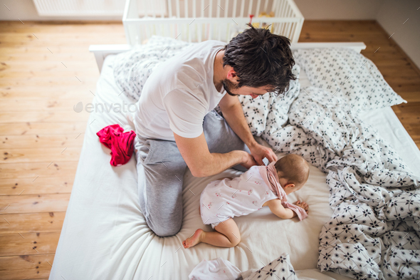 Father with a toddler girl on bed at home at bedtime. - Stock Photo - Images