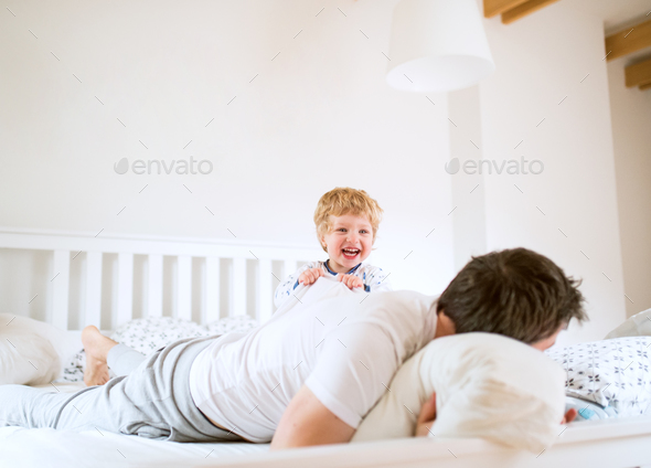 Father With A Toddler Boy Having Fun In Bedroom At Home At Bedtime