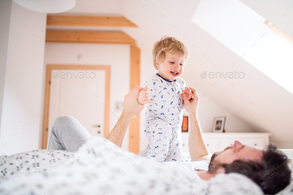 Father With A Toddler Boy Having Fun In Bedroom At Home At Bedtime