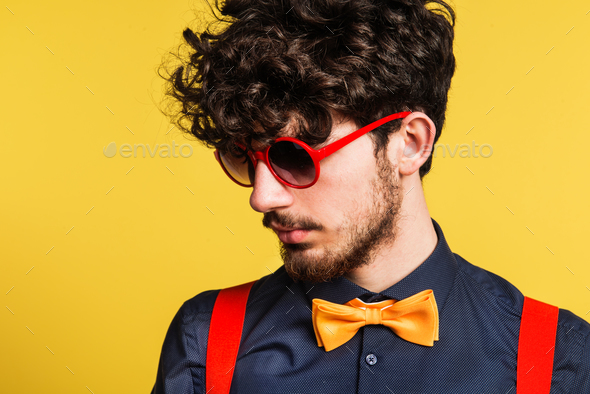 Portrait of a young man in a studio on a yellow background. - Stock Photo - Images