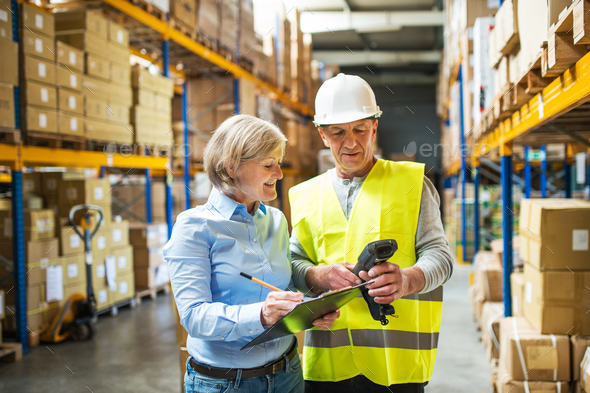 Senior woman manager and man worker working in a warehouse. - Stock Photo - Images