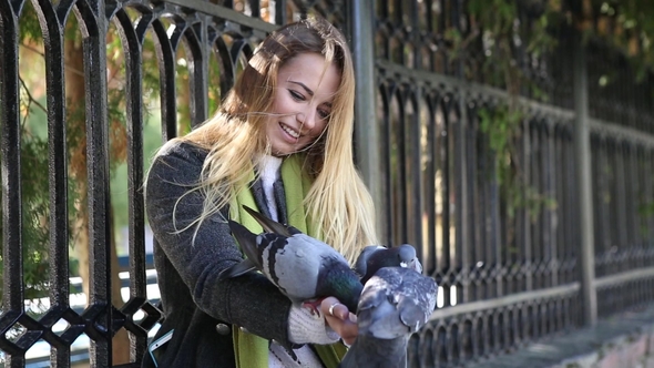 Beautiful Girl Feeding Pigeons