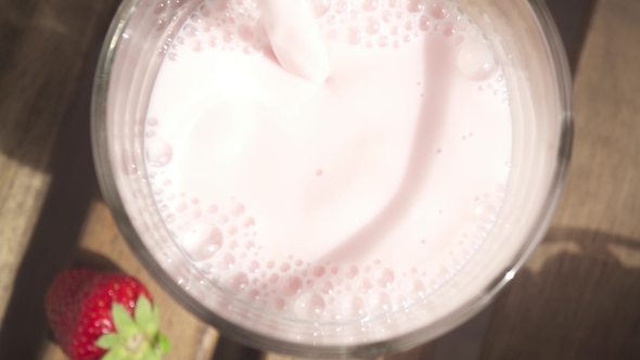 Milkshake Pours Into the Glass and the Camera Moves To the Strawberry
