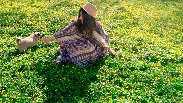 Young Girl Playing with Pug Dog in Spring Park. Dog Running and Having Fun