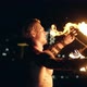 Young Blond Male Spins Two Burning Pois Tied Together. Slow Motion Shot. Close-up Shot.