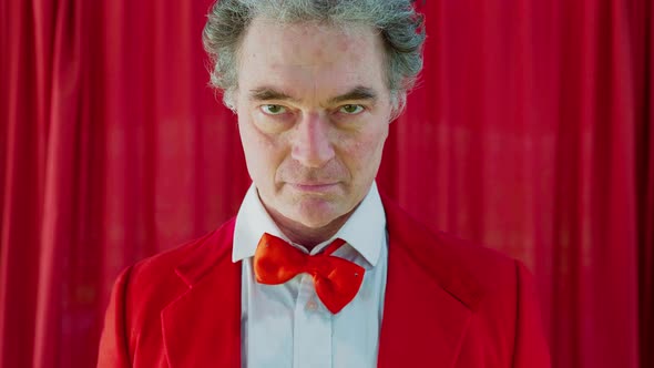 Portrait of circus director in red jacket looking at camera alt