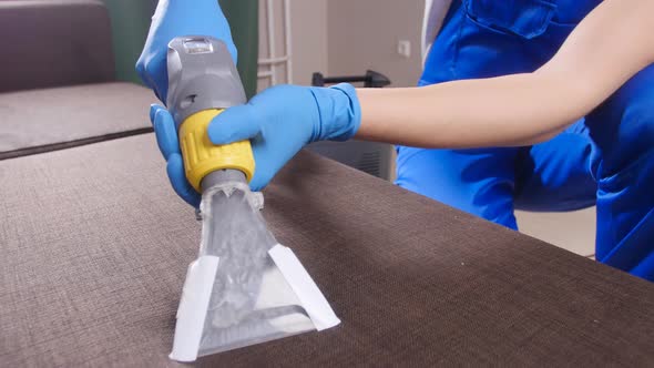 Concept of Cleaning in the Apartment and Office. Dry Cleaning Worker Removing Dirt From Sofa Indoors alt