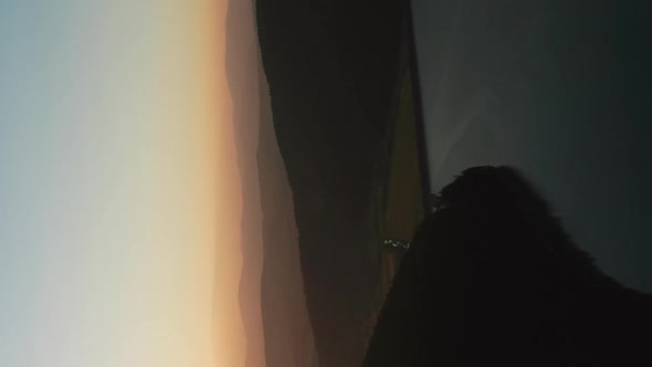 Vertical flyover above Frumoasa Dam, Romania at sunset. Distant mountain ranges alt