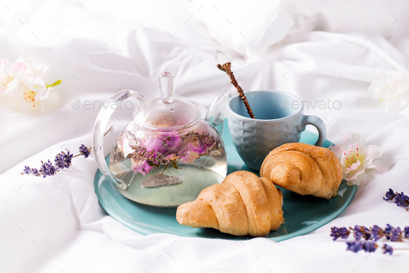 Breakfast in bed concept - french croissants with a cup of tea. - Stock Photo - Images