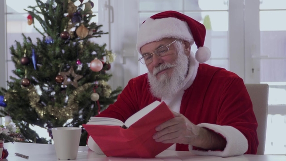 Santa Claus Is Drinking From A Cup And Reading A Book, Stock Footage