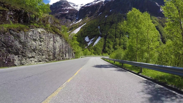 Driving a Car on a Serpentine Road in Norway alt