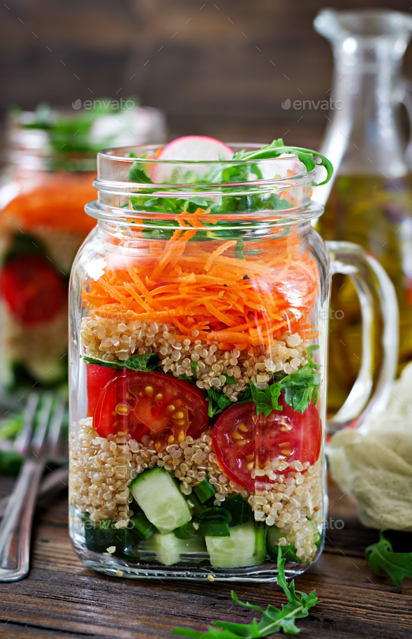 Salads with quinoa, arugula, radish, tomatoes and cucumber in glass jars - Stock Photo - Images